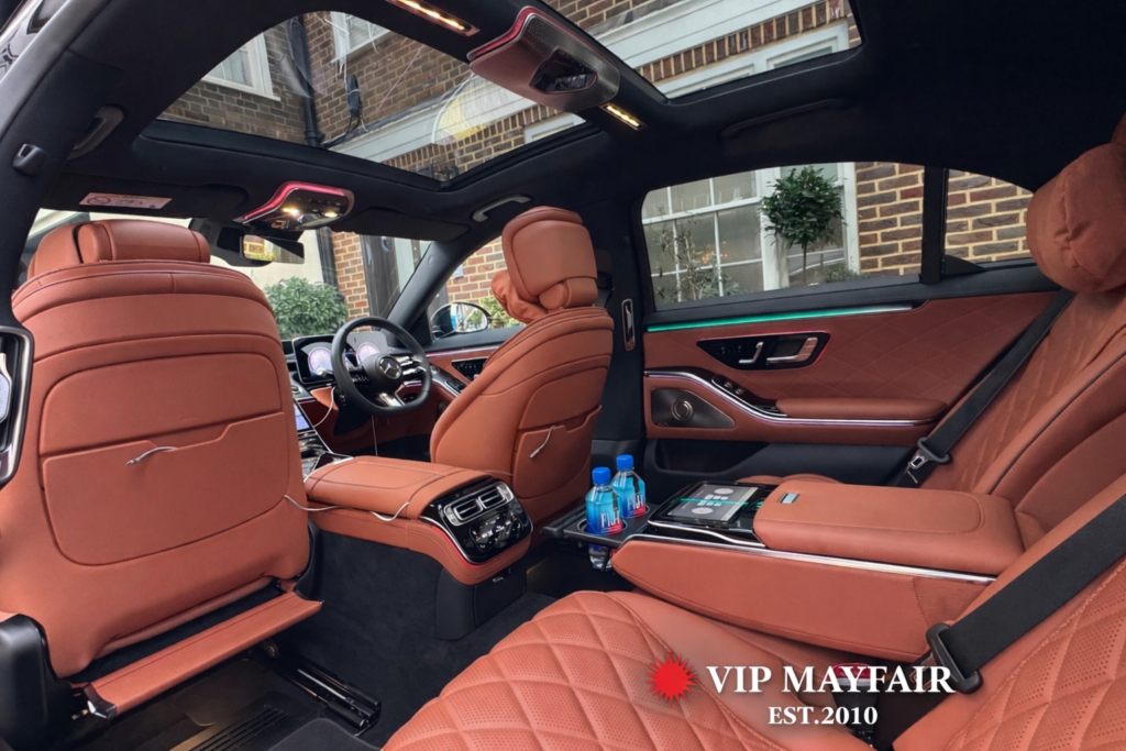 Luxury Mercedes-Benz S-Class interior with panoramic sunroof, leather seating and complimentary water bottles, VIP Mayfair chauffeur service.