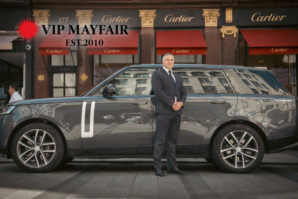 VIP Mayfair chauffeur standing next to black Range Rover luxury car in London, premium private hire service.